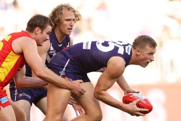 Josh Treacy of the Dockers looks to handball during the round 13 AFL match between the Fremantle Dockers and the Gold Coast Suns at Optus Stadium on...