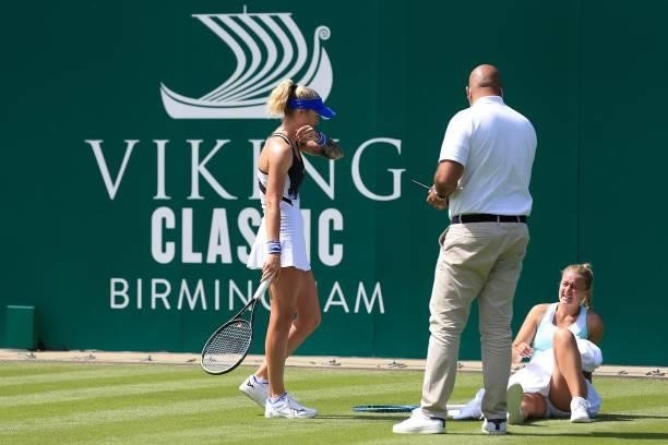 Dalila Jakupovic of Slovakia is helped up by Tereza Martincova of Czech Republic and Umpire Ramy Abdelhalem after slipping in qualifying during the...