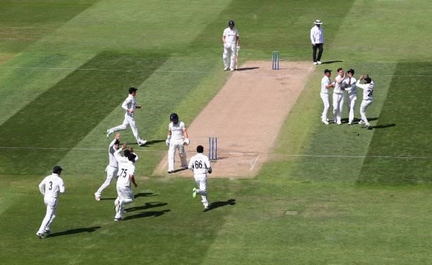 New Zealand bowler Matt Henry celebrates with team mates after taking the wicket of England opening batsman Rory Burns for 0 during day three of the...