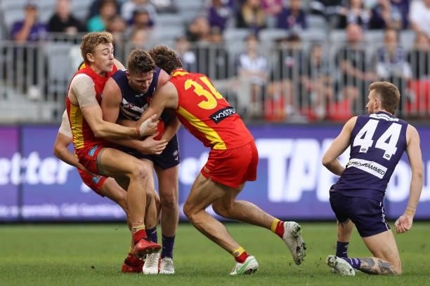 Hugh Greenwood and Ben King of the Suns tackle Luke Ryan of the Dockers during the round 13 AFL match between the Fremantle Dockers and the Gold...