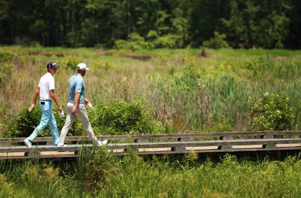 Chesson Hadley and Dustin Johnson walk from the second tee during the third round of the Palmetto Championship at Congaree on June 12, 2021 in...