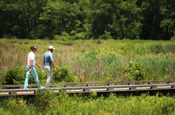 Chesson Hadley and Dustin Johnson walk from the second tee during the third round of the Palmetto Championship at Congaree on June 12, 2021 in...