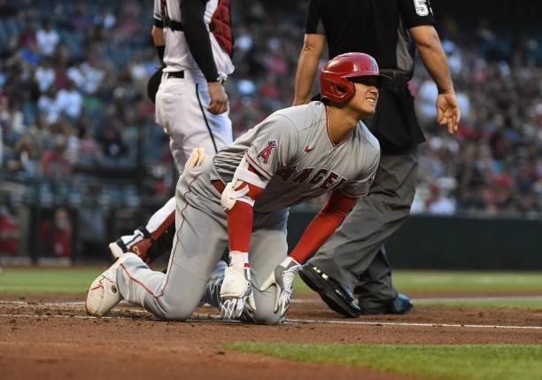 Shohei Ohtani of the Los Angeles Angels reacts after hitting a foul ball off of his knee during the third inning against the Arizona Diamondbacks at...