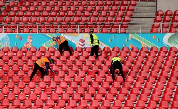 Volunteers disinfect the seats ahead of the UEFA Euro 2020 Championship Group B match between Denmark and Finland on June 12, 2021 in Copenhagen,...