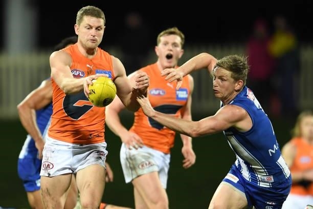 Jack Ziebell of the Kangaroos tries to block the kick by Jacob Hopper of the Giants during the round 13 AFL match between the North Melbourne...