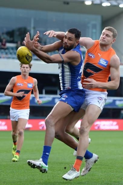 Tarryn Thomas of the Kangaroos and Jacob Hopper of the Giants compete for the ball during the round 13 AFL match between the North Melbourne...