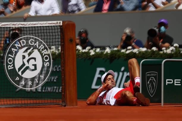 Novak Djokovic of Serbia reacts after falling to play a shot in his Men's Singles Final match against Stefanos Tsitsipas of Greece during Day Fifteen...