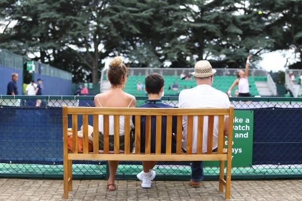 Spectatorswatch the action from a wooden bench during day 1 of the Nottingham Trophy at Nottingham Tennis Centre on June 13, 2021 in Nottingham,...