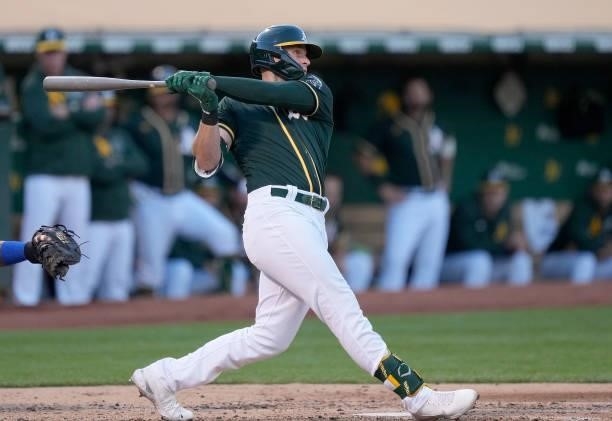 Seth Brown of the Oakland Athletics swings and watches the flight of his ball as he hits a two-run home run against the Kansas City Royals in the...