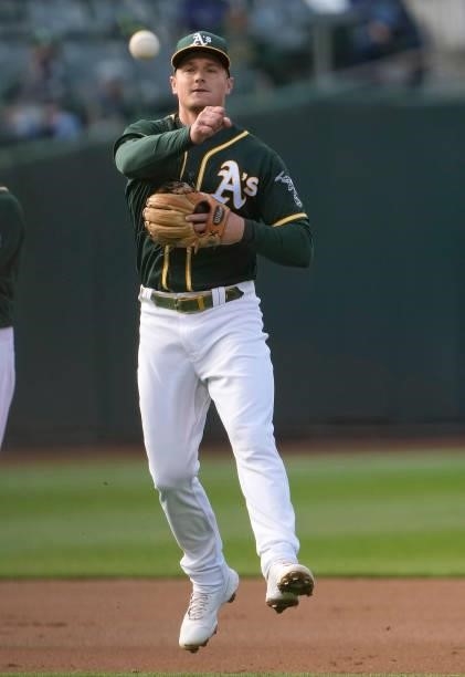 Matt Chapman of the Oakland Athletics throws off balance to first base throwing out Carlos Santana of the Kansas City Royals in the top of the first...