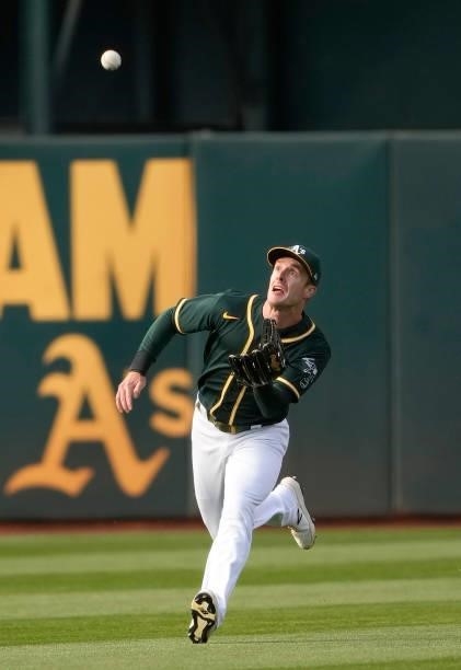 Mark Canha of the Oakland Athletics makes a running catch taking a hit away from Salvador Perez of the Kansas City Royals in the top of the first...