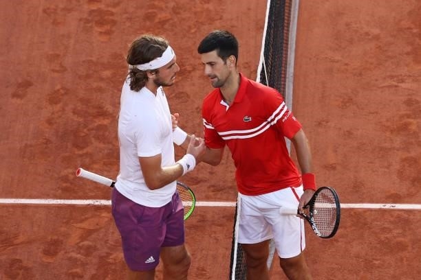 Winner Novak Djokovic of Serbia and runner-up Stefanos Tsitsipas of Greece shake hands at the net after their Men's Singles Final match during Day...