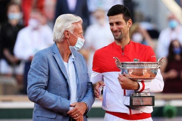Novak Djokovic of Serbia talks with former tennis player Bjorn Borg as he holds the trophy after winning his Men's Singles Final match against...