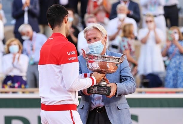 Novak Djokovic of Serbia interacts with former tennis player Bjorn Borg as receives the trophy after winning his Men's Singles Final match against...
