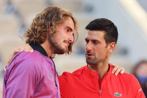 Runner-up Stefanos Tsitsipas of Greece is consoled by winner Novak Djokovic of Serbia on the podium after the Men's Singles Final match during Day...