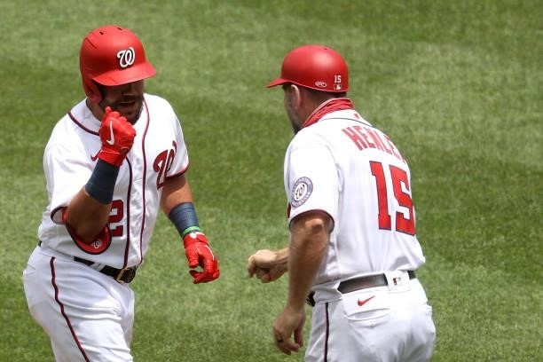 Kyle Schwarber of the Washington Nationals celebrates with third base coach Bob Henley after hitting a solo home run in the first inning against the...