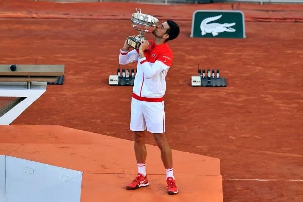 Novak Djokovic of Serbia kisses the Mousquetaires trophy after winning his Men's Singles Final match against Stefanos Tsitsipas of Greece during Day...