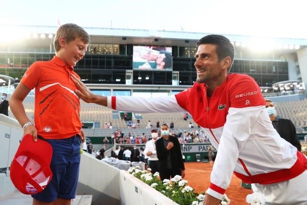 Tournament winner Novak Djokovic of Serbia celebrates with a young fan after winning his Men's Singles Final match against Stefanos Tsitsipas of...