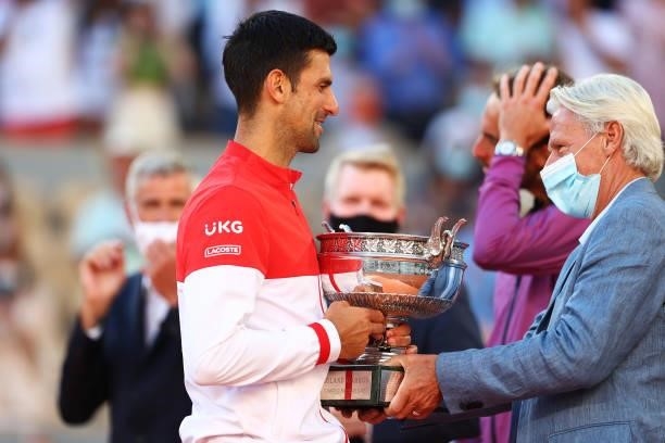 Novak Djokovic of Serbia talks with former tennis player Bjorn Borg as receives the trophy after winning his Men's Singles Final match against...