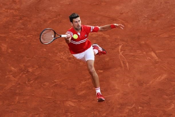 Novak Djokovic of Serbia stretches to play a forehand in his Men's Singles Final match against Stefanos Tsitsipas of Greece during Day Fifteen of the...