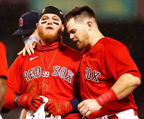 Bobby Dalbec of the Boston Red Sox puts his arm around Alex Verdugo of the Boston Red Sox after the win over the Toronto Blue Jays at Fenway Park on...