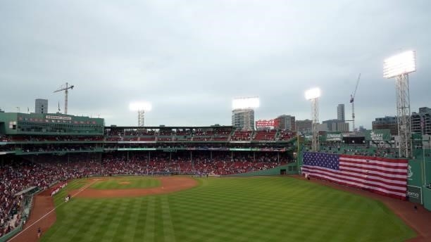 The American Flag covers the Green Monster during the National Anthem before the game between the Boston Red Sox and the Toronto Blue Jays at Fenway...