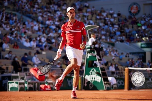 Novak Djokovic of Serbia taps clay out of his shoes in his Men's Singles Final match against Stefanos Tsitsipas of Greece during day fifteen of the...