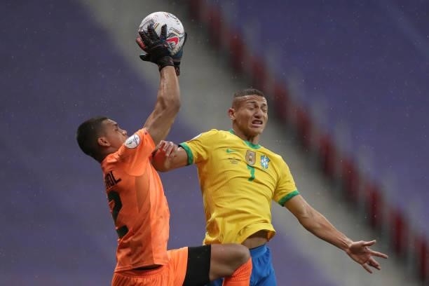 Joel Graterol goalkeeper of Venezuela jumps to control the ball against Richarlison of Brazil during a Group B match between Brazil and Venezuela as...
