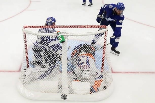Mathew Barzal of the New York Islanders crashes into Andrei Vasilevskiy of the Tampa Bay Lightning after scoring a goal past him during the second...