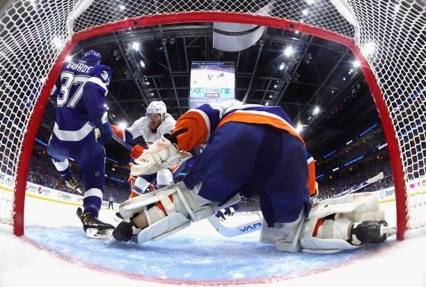 Ryan Pulock and Semyon Varlamov of the New York Islanders defend against Yanni Gourde of the Tampa Bay Lightning in Game One of the Stanley Cup...