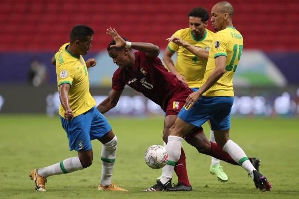 Sergio Cordova of Venezuela competes for the ball with Alex Sandro and Fabinho of Brazil during a Group B match between Brazil and Venezuela as part...