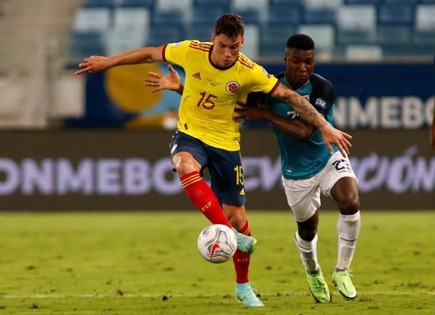 Mateus Uribe of Colombia competes for the ball with Moises Caicedo of Ecuador during a Group B match between Ecuador and Colombia at Arena Pantanal...