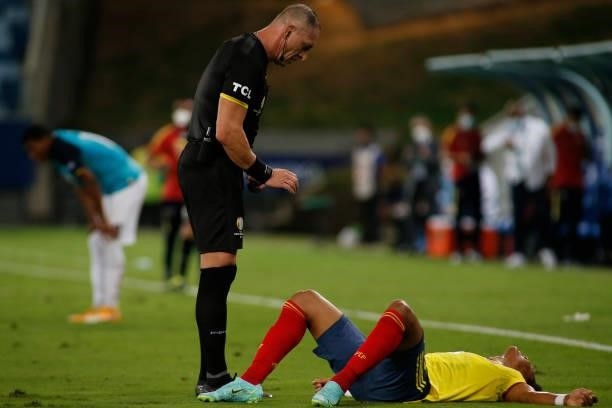 Referee Néstor Pitana checks on Yairo Moreno of Colombia after a foul during a Group B match between Ecuador and Colombia at Arena Pantanal on June...