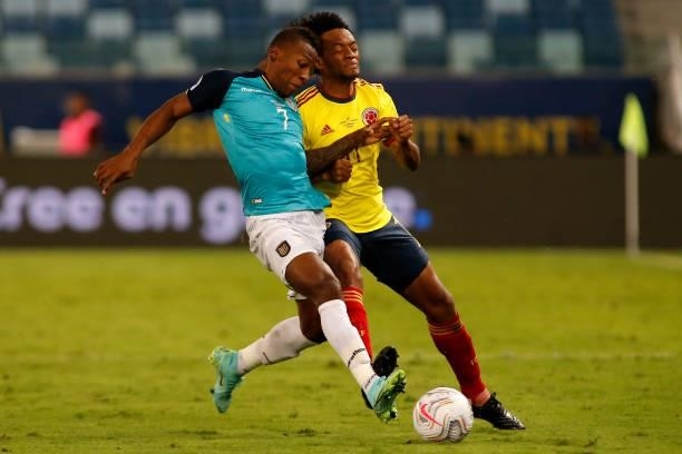 Pervis Estupiñan of Ecuador competes for the ball with Juan Cuadrado of Colombia during a Group B match between Ecuador and Colombia at Arena...