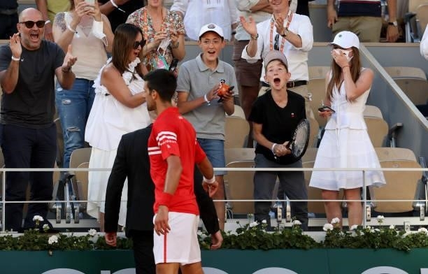 Novak Djokovic of Serbia gives his racket to a lucky and happy fan who cheered for him all match long after winning the Men's Singles final on day 15...