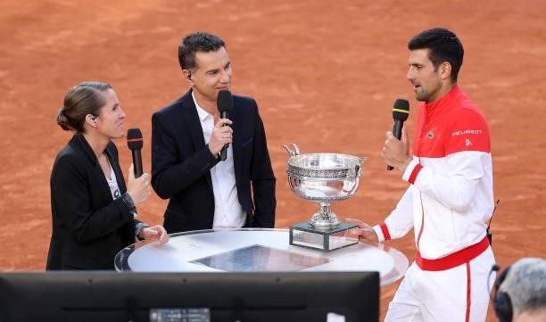 Novak Djokovic of Serbia is interviewed by Justine Henin and Laurent Luyat of France Televisions following his victory in the Men's Singles final on...