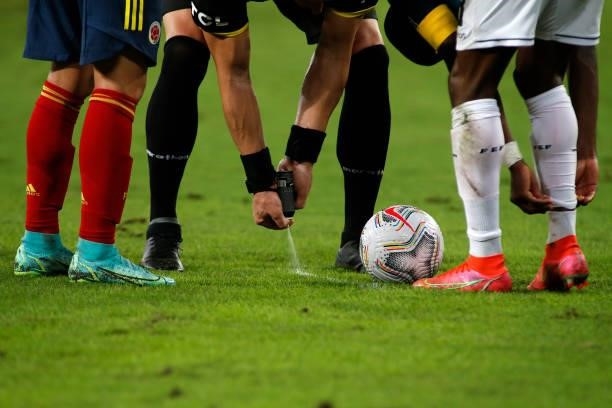 Referee Néstor Pitana applies vanishing spray onto the pitch for a free kick during a Group B match between Ecuador and Colombia at Arena Pantanal on...