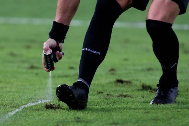 Referee Néstor Pitana applies vanishing spray onto the pitch for a free kick during a Group B match between Ecuador and Colombia at Arena Pantanal on...
