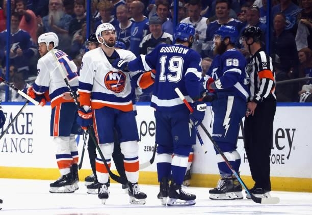 Adam Pelech of the New York Islanders is held off by Barclay Goodrow of the Tampa Bay Lightning just eight seconds into their match in Game One of...