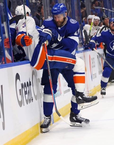 Adam Pelech of the New York Islanders is checked by Barclay Goodrow of the Tampa Bay Lightning in Game One of the Stanley Cup Semifinals during the...