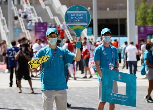 Volunteers hold up signs reminding fans to get ready for Covid checks ahead of the UEFA Euro 2020 Championship Group D match between England and...