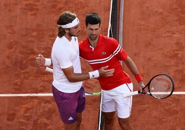 Winner Novak Djokovic of Serbia and runner-up Stefanos Tsitsipas of Greece shake hands at the net after their Men's Singles Final match during Day...