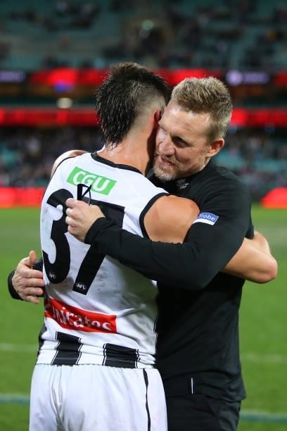 Nathan Buckley, Senior Coach of the Magpies celebrates victory with Kade Chandler of the Demons during the round 13 AFL match between the Melbourne...