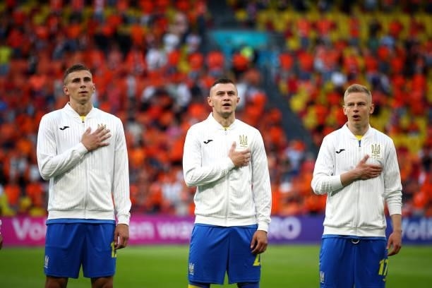 Illia Zabarnyi, Oleksandr Karavaev and Oleksandr Zinchenko of Ukraine sing their national anthem during the UEFA Euro 2020 Championship Group C match...
