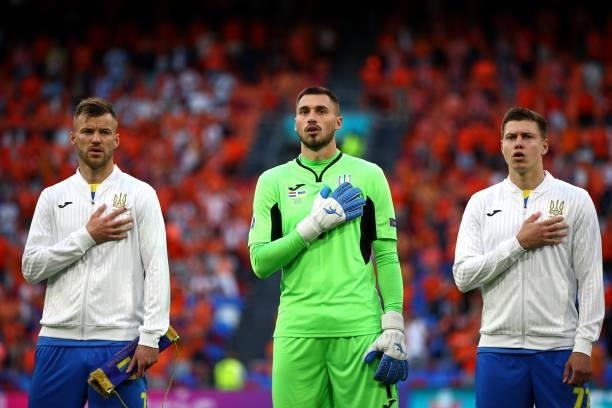 Andriy Yarmolenko, Georgiy Bushchan and Mykola Matviyenko sing their national anthem during the UEFA Euro 2020 Championship Group C match between...
