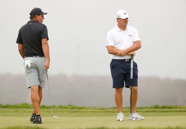 Phil Mickelson of the United States and Bryson DeChambeau of the United States stand on the 14th green prior to the start of the 2021 U.S. Open at...