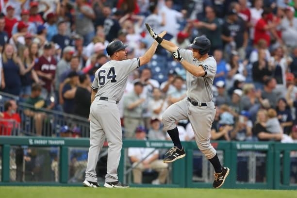 LeMahieu of the New York Yankees high fives coach Carlos Mendoza after he hit a three-run home run to tie the game in the ninth inning against the...