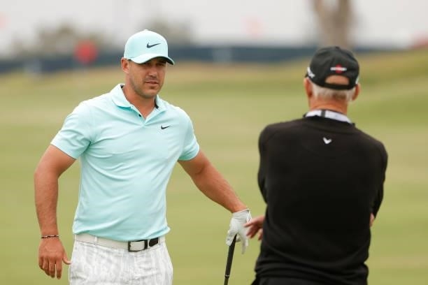 Brooks Koepka of the United States talks with coach Pete Cowen during a practice round prior to the start of the 2021 U.S. Open at Torrey Pines Golf...