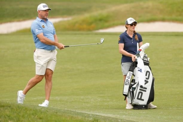 Lee Westwood of England plays a shot on the fifth hole as caddie Helen Storey looks on during a practice round prior to the start of the 2021 U.S....