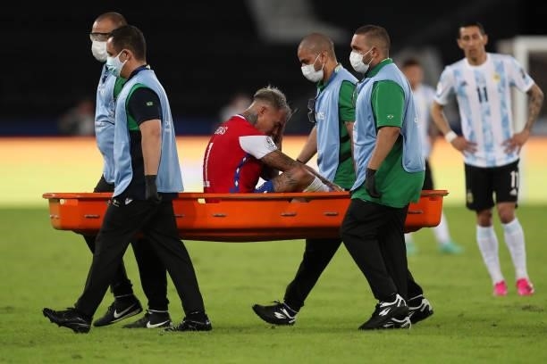 Eduardo Vargas of Chile leaves the field in a stretcher after being injured during a Group A match between Argentina and Chile at Estadio Olímpico...